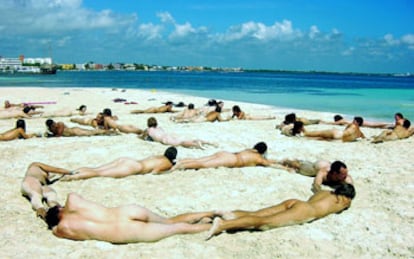 Manifestantes antiglobalización forman un "No a la OMC" en una playa de Cancún.