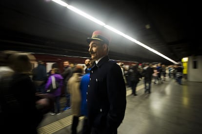 Passatgers a l'andana des d'on la matinada passada han pujat al túnel del temps del metro. En primer pla, un treballador del Metro amb l'uniforme de fa gairebé un segle.