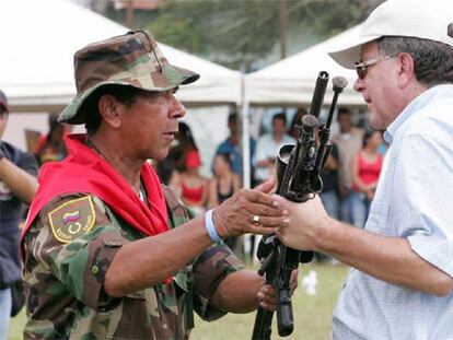 Ramón Isaza (izquierda) entrega su arma al alto comisionado para la Paz, Luis Carlos Restrepo.