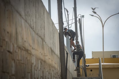 Dos jóvenes se escapan el jueves de las naves de El Tarajal, en Ceuta, cuando iban a ser trasladados en un autobús de la Guardia Civil.