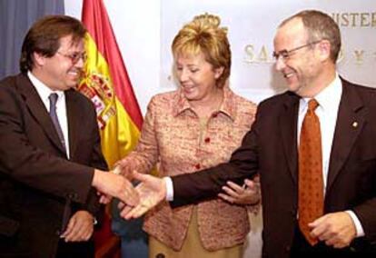 Celia Villalobos estrecha la mano al presidente de Farmaindustria, Jesús Acebillo (izquierda), y al consejero catalán Eduard Rius, en su calidad de vicepresidente del Consejo Interterritorial de Salud, tras el acuerdo firmado ayer.