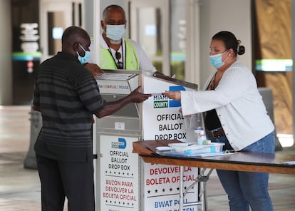 Una trabajadora electoral ayuda a un hombre a votar en Miami (Florida), en 2020.