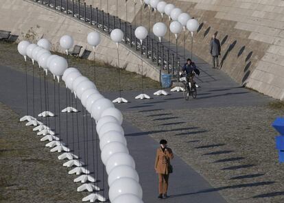 Una mujer camina junto a los globos de la instalación Frontera de luz instalados en la ribera del río Spree por la institución Robert-Havemann Gesellschaf. Entre el 7 y el 9 de Noviembre la instalación recordara la caída de la frontera que durante 25 años dividió la ciudad