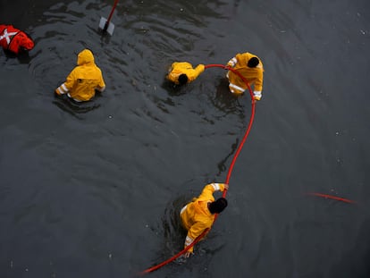 Government employees work to drain a flooded overpass as tropical storm Alberto continues to advance in Monterrey, Mexico on June 19, 2024.