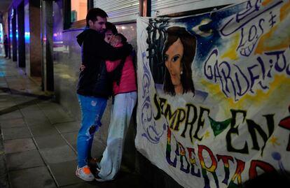 Una pareja que atestiguó la agresión de Fernando André Sabag a Fernández de Kirchner se abraza junto a una pancarta que muestra su apoyo a la vicepresidenta.