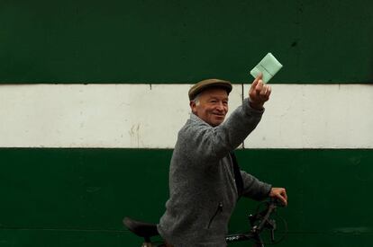 Antonio Toscano, de 71 años, posa para una foto delante de una pared con los colores de la bandera andaluza antes de emitir su voto para en un colegio electoral de Cuevas del Becerro, Málaga.