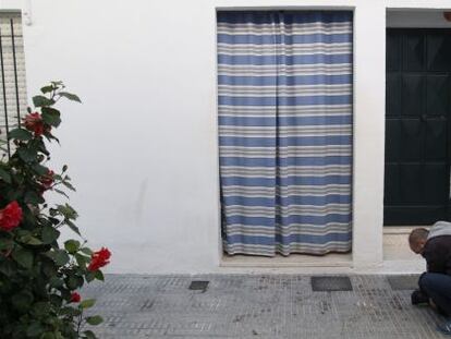 Un càmera pren imatges de taques de sang a la porta de l'habitatge on ha tingut lloc el succés.