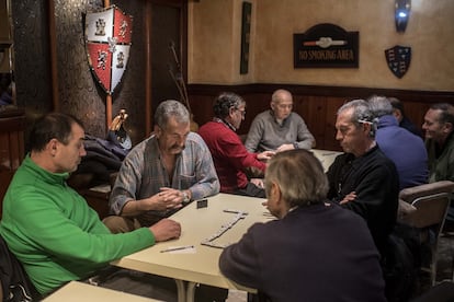 Jubilados en Ciñera, León, juegan al dominó en un bar.