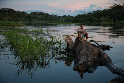 Un niño sobre un tronco en medio del brazo de un río. En estas aguas abundan los peces, pero es más difícil pescarlos cuando, por las lluvias, el río se mete a los bosques. 