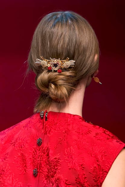 Usar un pasador o adorno para darle un toque diferente a un moño básico y despeinado. Una propuesta de Dolce & Gabbana que puedes copiar en Nochevieja.