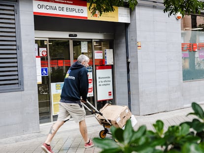 Un repartidor pasa por la oficina del paro de Paseo de las Acacias, el mes de octubre en Madrid.