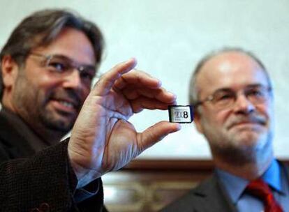 Castells entrega al presidente del Parlament, Ernest Benach, una tarjeta electrónica con las cuentas.