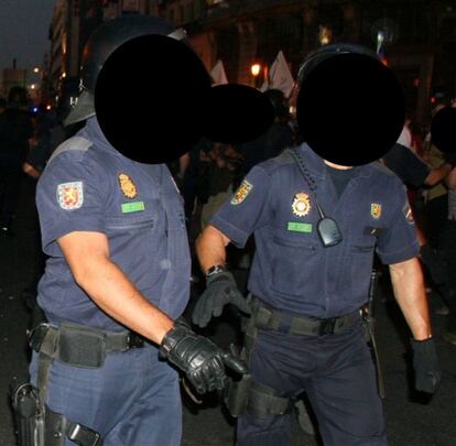 Un par de 'antidisturbios' sin el número identificativo que exige la instrucción 13/2007, relativa al uso del número de identificación personal en los Cuerpos y Fuerzas de Seguridad del Estado. Esta norma recoge que los ciudadanos tienen derecho a conocer la identidad de los funcionarios policiales y adscripción de los mismos.