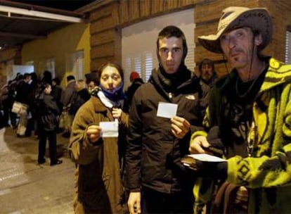 Minea, Manuel y Agustín (de izquierda a derecha) muestran sus cartillas para cenar en el comedor de Casa de Campo.