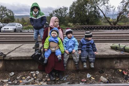 Una mujer y sus hijos esperan un tren después de cruzar la frontera entre Serbia y Macedonia en la localidad de Bujanovac el pasado 23 de octubre.