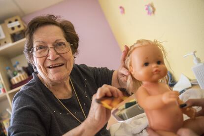 Rosario Vega peina a una de las muñecas, después de lavarla. "Así trabajamos el esquema corporal, la postura que utiliza al asearla", cuenta Ana Sanz, la terapeuta ocupacional. En la terapia no solo están involucrados los pacientes que son tratados, sino otros residentes. "Se crea una atmósfera especial alrededor de los muñecos", cuenta Sanz.