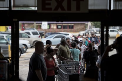 Una gran cola se forma ante una tienda donde la gente espera para hacerse con provisiones tras el paso del huracán Harvey, en Houston.