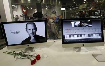 Unos claveles colocados delante de una pantalla con el retrato de Steve Jobs rinden tributo a su memoria en la tienda de Apple en San Petersburgo