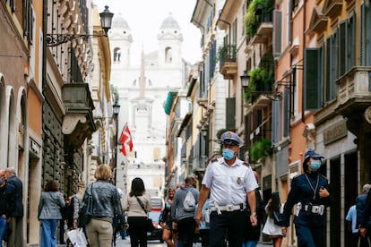 Un policía municipal con mascarilla patrulla por la via Condotti de Roma, ciudad en la que ya es obligatorio portarla todo el día.