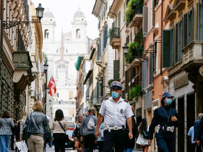 Un policía municipal con mascarilla patrulla por la via Condotti de Roma, ciudad en la que ya es obligatorio portarla todo el día.