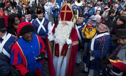 Papá Noel escoltado por el paje negro.
