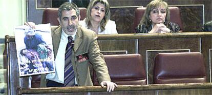 El coordinador general de IU, Gaspar Llamazares, muestra durante el pleno del Congreso una fotografía de una niña mutilada en la guerra de Irak.