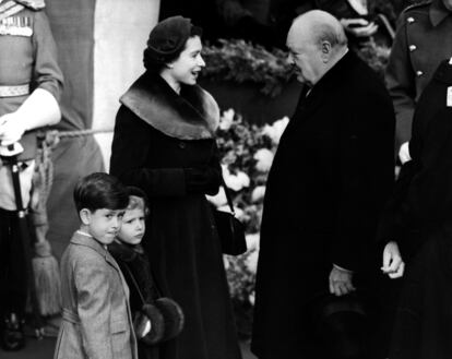 Isabell II, acompañada de sus hijos Carlos y Ana, charla con el primer ministro británico, Winston Churchill, en una imagen tomada en 1953.