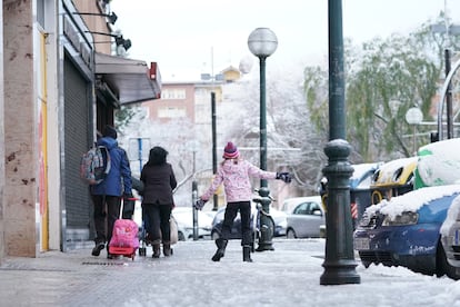 Varias personas pasan por una calle con nieve y hielo, a 18 de enero de 2023, en Vitoria-Gasteiz (País Vasco). La ciudad de Vitoria ha amanecido cubierto de un manto blanco de nieve después de que bajara la cota de nieve a los 200 metros.