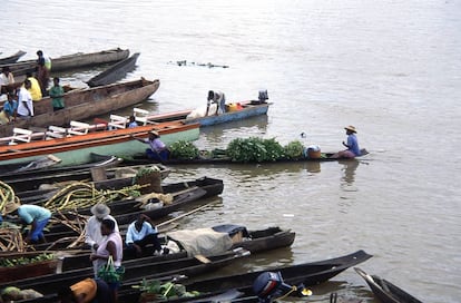 Agricultores en barcas transportando frutas por el río Atrato en Quibdó, Colombia.