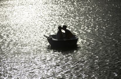 Una pareja se besa en una barca en el parque de El Retiro de Madrid.