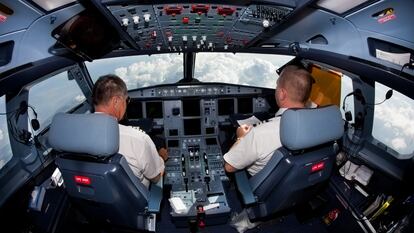 Pilotos de aerolínea en vuelo.