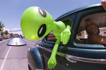 Un muñeco alienígena cuelga de la ventana de un automóvil en el centro de Roswell, Nuevo México, el 1 de julio de 2000 como parte del Festival OVNI anual.