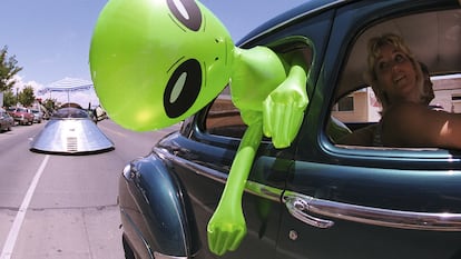 Un muñeco alienígena cuelga de la ventana de un automóvil en el centro de Roswell, Nuevo México, el 1 de julio de 2000 como parte del Festival OVNI anual.