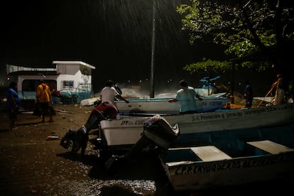 Pescadores aseguran un bote mientras el huracán toca tierra, en Puerto Escondido, Oaxaca.