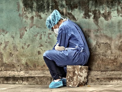 Una mujer, protegida con un traje de bioseguridad, descansa en el Instituto Cardiopulmonar El Tórax de Tegucigalpa (Honduras).