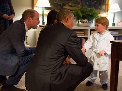 O príncipe George, de roupão, cumprimenta o presidente Obama.