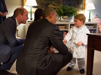 O príncipe George, de roupão, cumprimenta o presidente Obama.