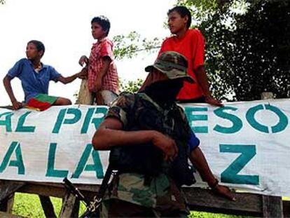 Un miembro de las AUC hacía guardia ayer ante un grupo de niños en la carretera de acceso a Santa Fe de Ralito.