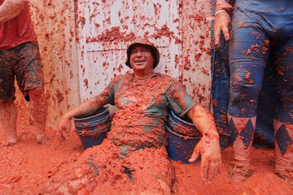 Un hombre se sienta sobre el suelo repleto de tomates durante la tradicional Tomatina de Buñol, este jueves.
