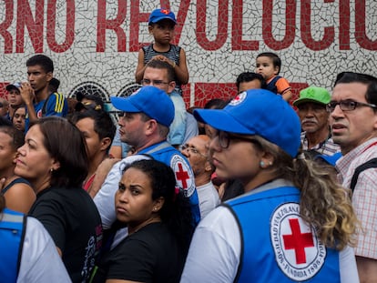 Personas esperan para recibir ayuda de trabajadores de la Cruz Roja en Venezuela.
