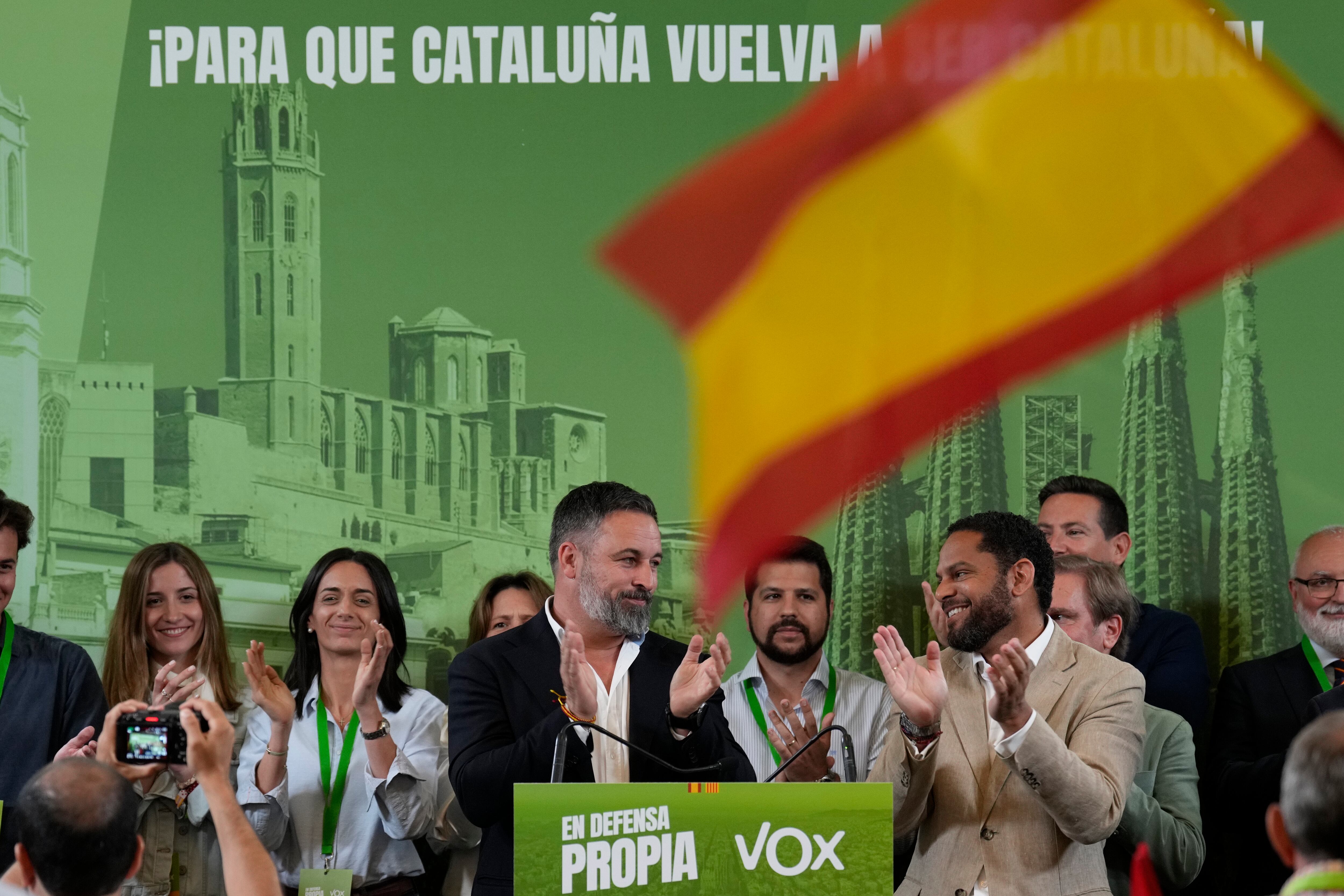 El presidente de Vox, Santiago Abascal (en el centro), y el candidato de la formación a la presidencia de la Generalitat, Ignacio Garriga (a la derecha), durante la rueda de prensa para valorar los resultados obtenidos por la formación política este domingo en las elecciones catalanas. 