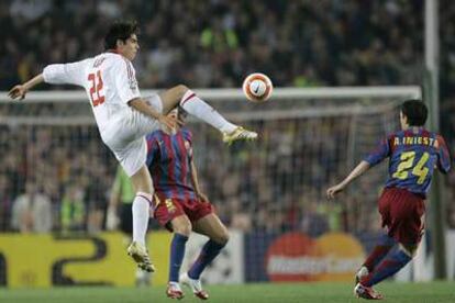 Iniesta se dispone a interceptar un pase forzado de Kaká por delante de Puyol.