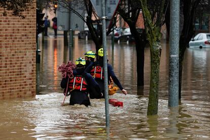 Tres miembros del personal de emergencias caminan por una calle inundada en Pamplona (Navarra). Las lluvias que azotan el País Vasco y Navarra en los últimos días están provocando numerosas incidencias, principalmente por el desbordamiento de ríos y los desprendimientos de tierra que están afectando a varias localidades y a carreteras, principalmente de la red secundaria.