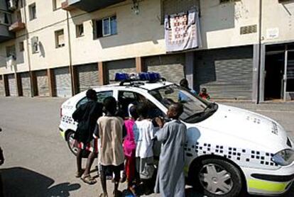 Unos niños observan un vehículo policial en la plaza de Banyoles, en la que fueron detenidos los secuestradores.