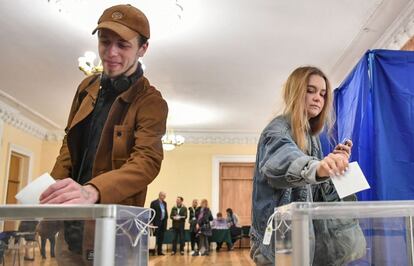 Unos jóvenes ejercen su derecho al voto en un colegio electoral en Kiev (Ucrania).