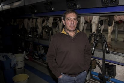 Ángel López García, ganadero de Guntin (Lugo), delante de la ordeñadora automática de su explotación de 400 vacas. Actualmente pierde 12.000 euros al mes.