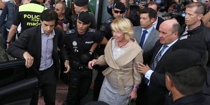 Gutiérrez Moliner, a la derecha, ayuda a Aguirre a entrar en el coche tras declarar ante el juez