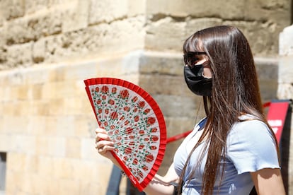 Una mujer se abanica mientras pasea por el centro de Córdoba.