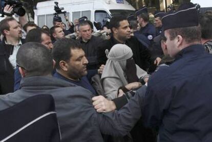 La policía francesa detiene a una mujer con <i>niqab</i> durante una protesta no autorizada por el veto al velo integral en París.