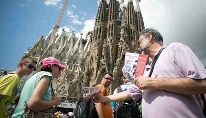 Repartiment de díptics a turistes davant de la Sagrada Família.